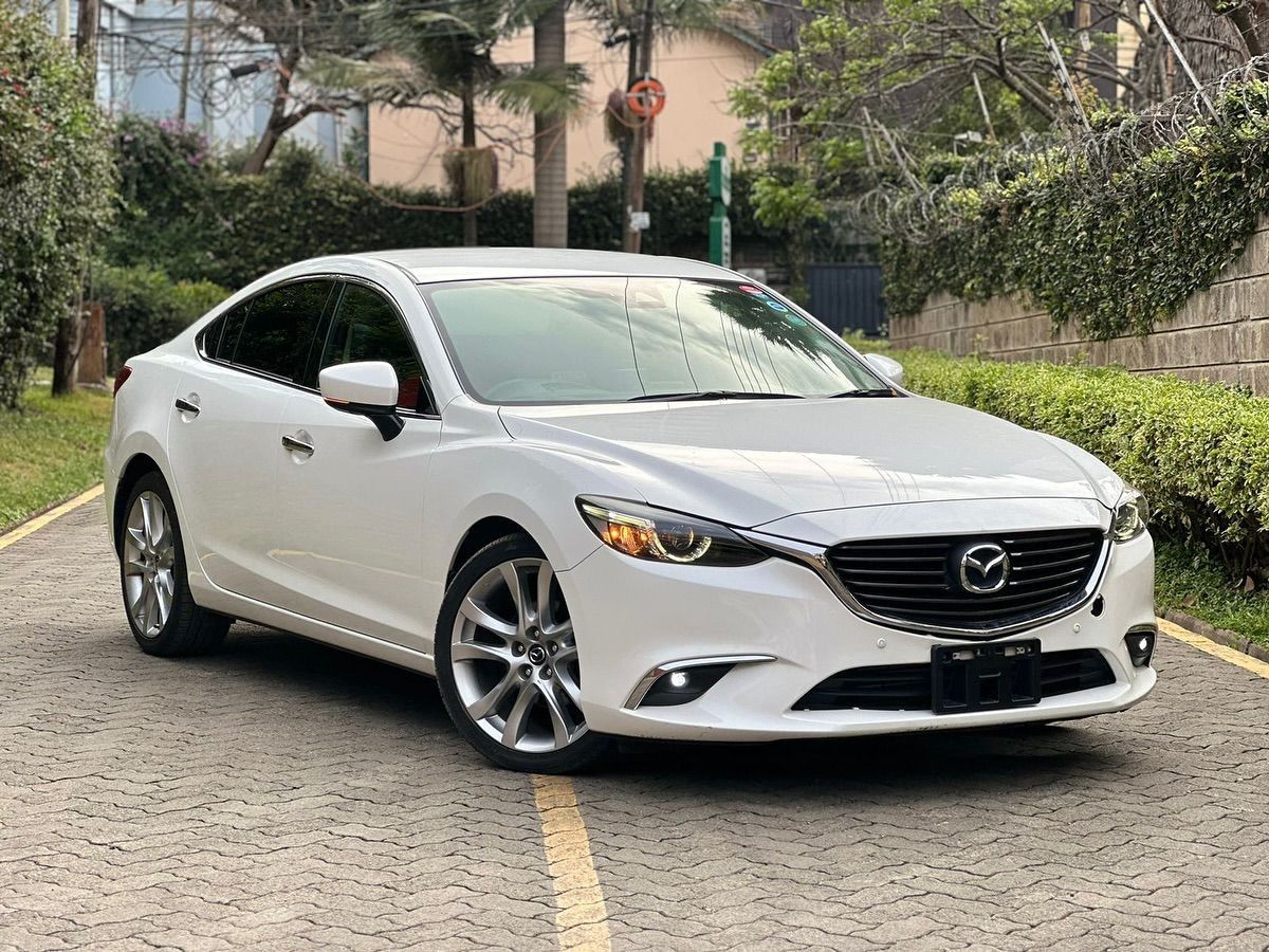 A clean white saloon parked on a Nairobi street